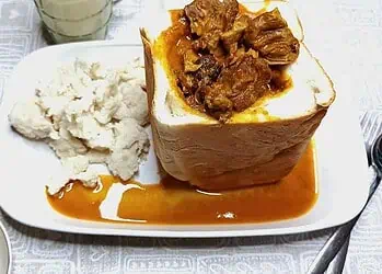 South African lamb curry bunny chow served in a hollowed white loaf