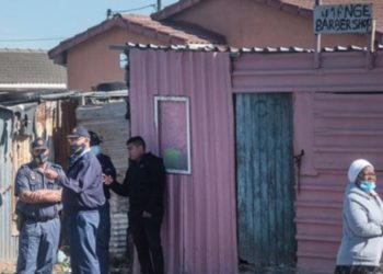 Police stand next to the place where five bodies were discovered in Khayelitsha