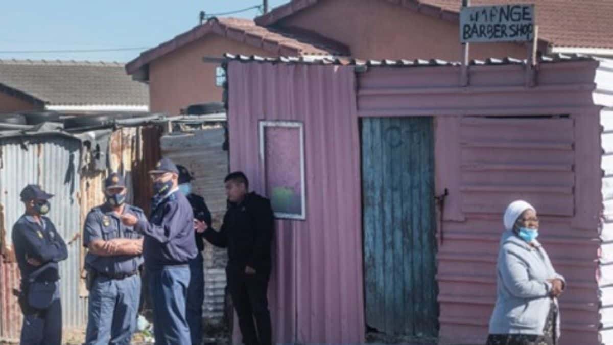 Police stand next to the place where five bodies were discovered in Khayelitsha