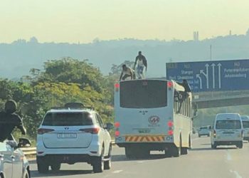 Bus surfers dance on top of a moving bus on the N3 freeway in Durban.