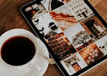 Horoscopes and Lucky Numbers for 18 June - Saffarazzi Tablet displaying a collage of travel photos beside a cup of black coffee on a wooden table.