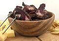 Sliced beef and game biltong served in a wooden bowl with cheese and crisps.