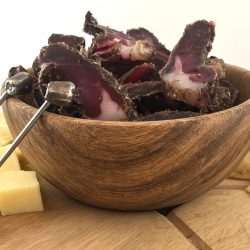 Beef and game biltong recipe - Saffarazzi Sliced beef and game biltong served in a wooden bowl with cheese and crisps.