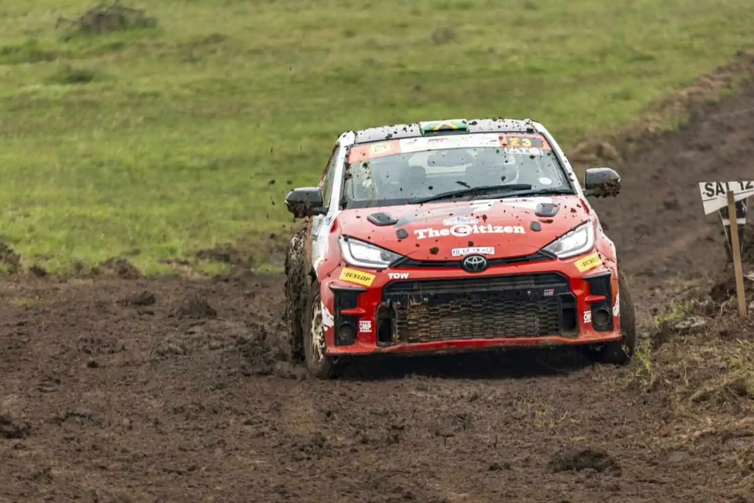 Mud-splattered Toyota GR Yaris rally car on wet stage - Saffarazzi Mud-splattered Toyota GR Yaris rally car on wet stage