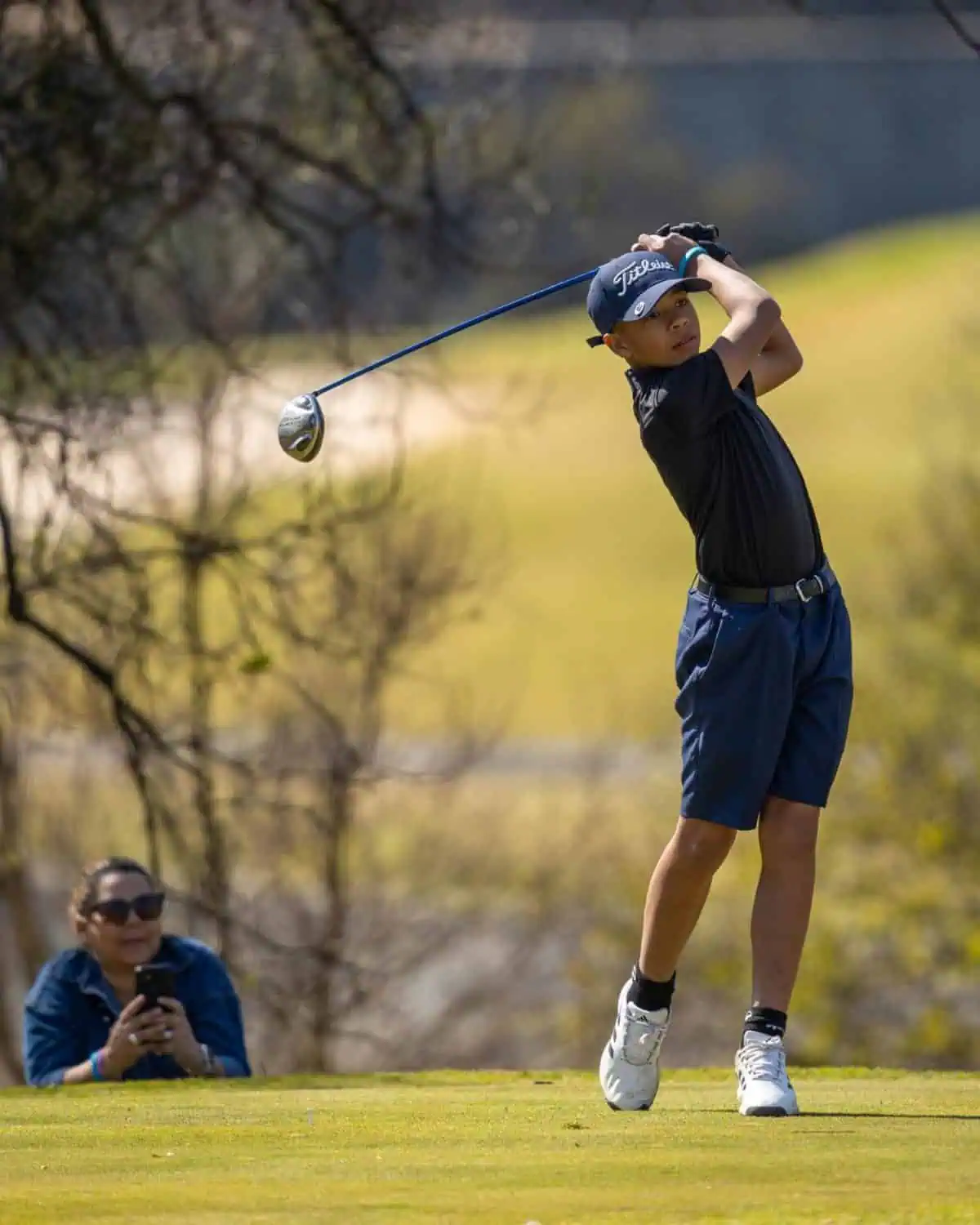 Young golfer follows through on tee shot - Saffarazzi Young golfer follows through on tee shot