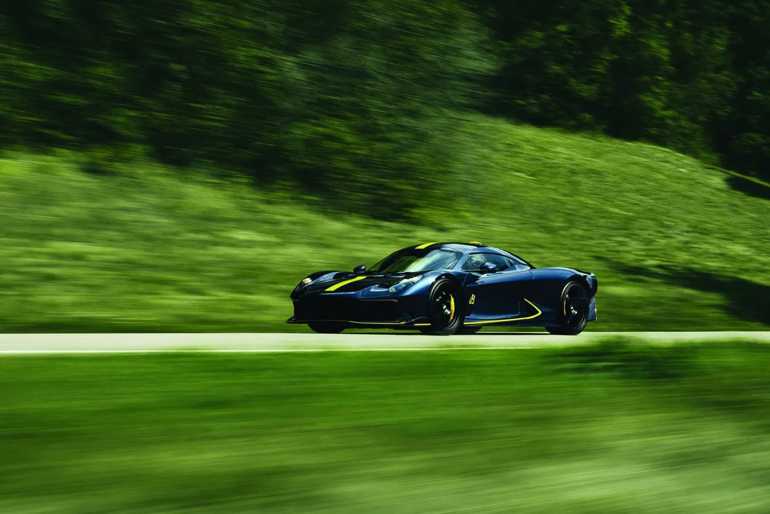 Aston Martin Valhalla supercar driving past green hillside - Saffarazzi Aston Martin Valhalla supercar driving past green hillside
