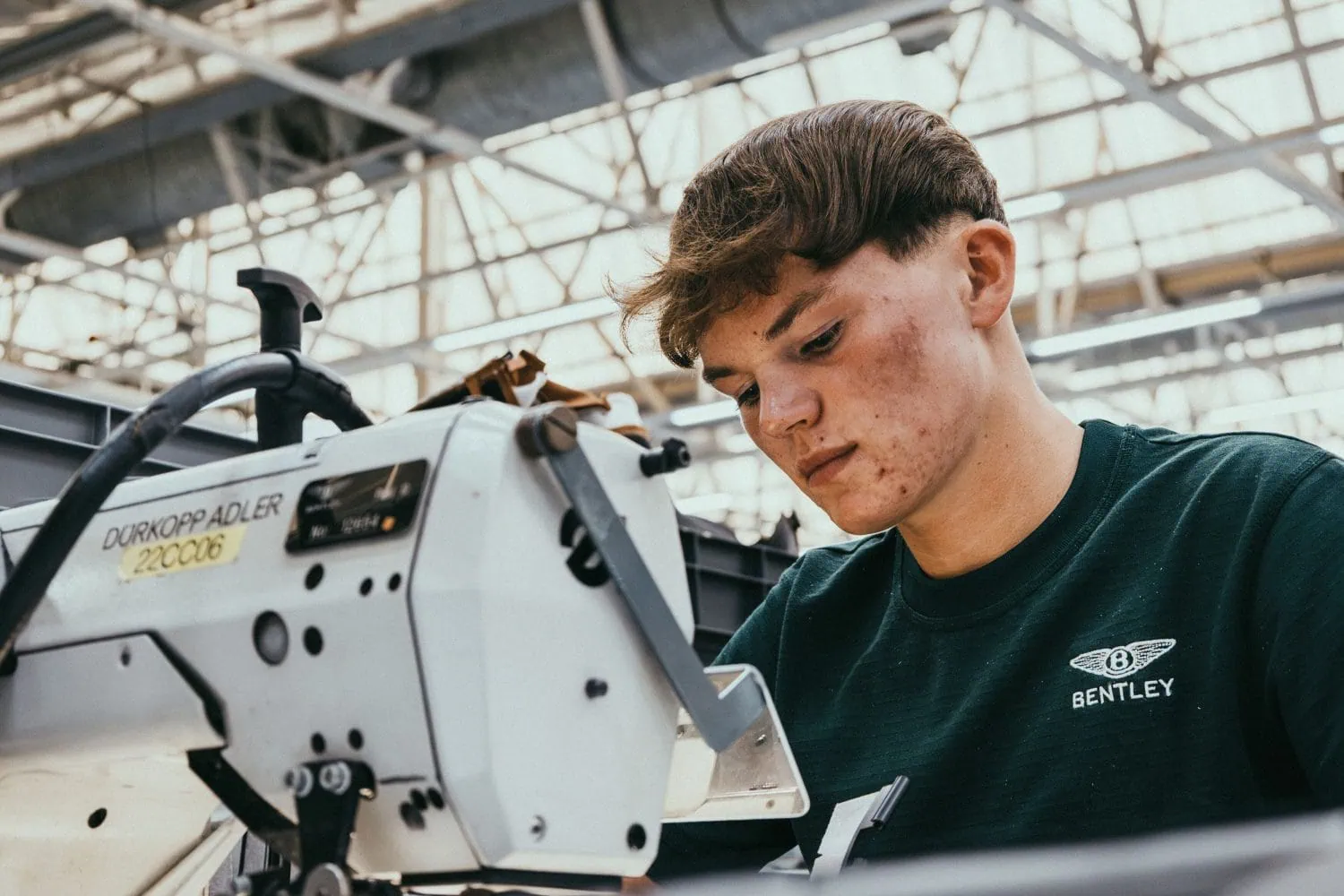 Bentley apprentice using sewing machine in trim shop - Saffarazzi Bentley apprentice using sewing machine in trim shop