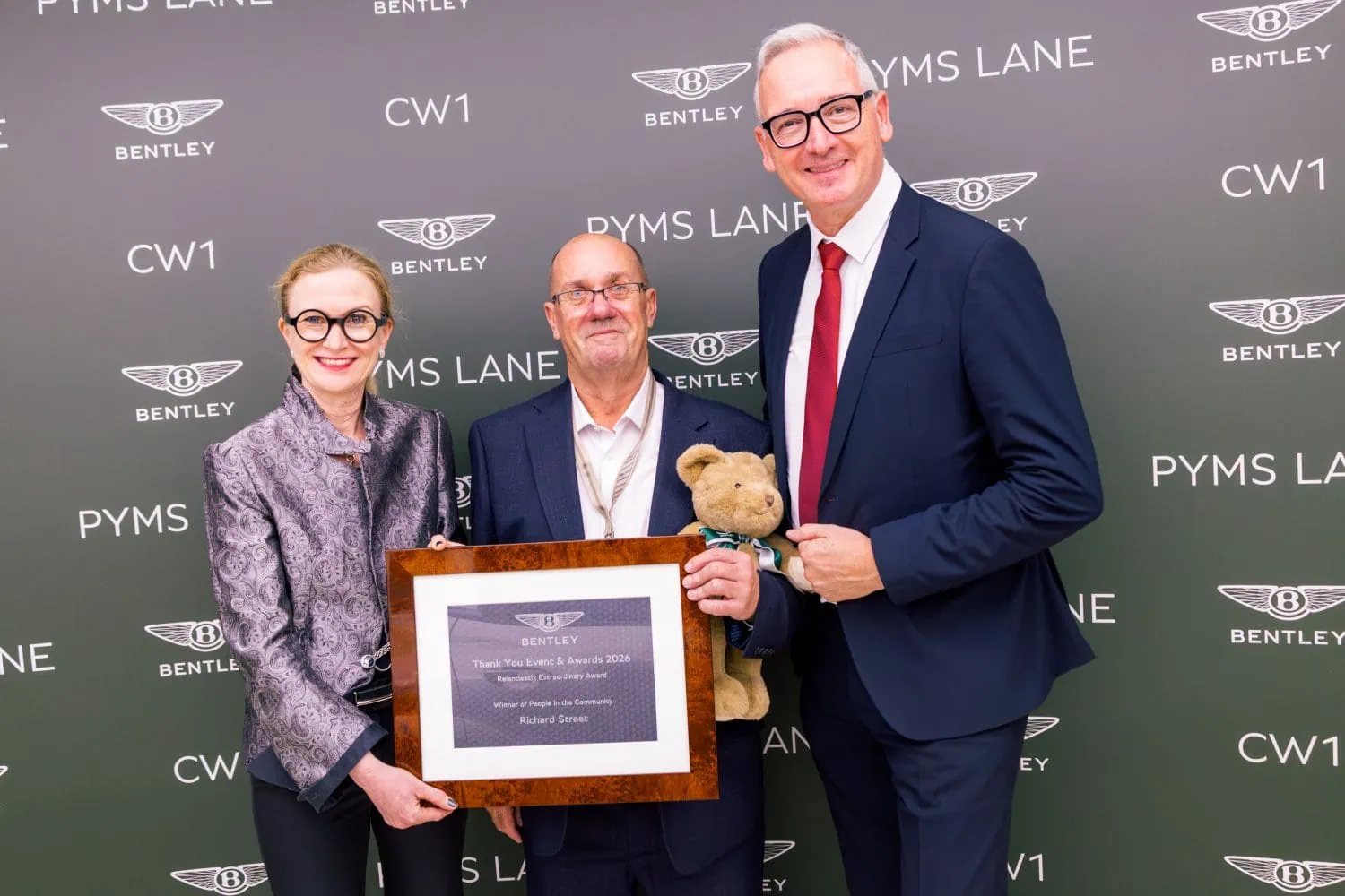 Bentley community award winner holding plaque and teddy bear - Saffarazzi Bentley community award winner holding plaque and teddy bear