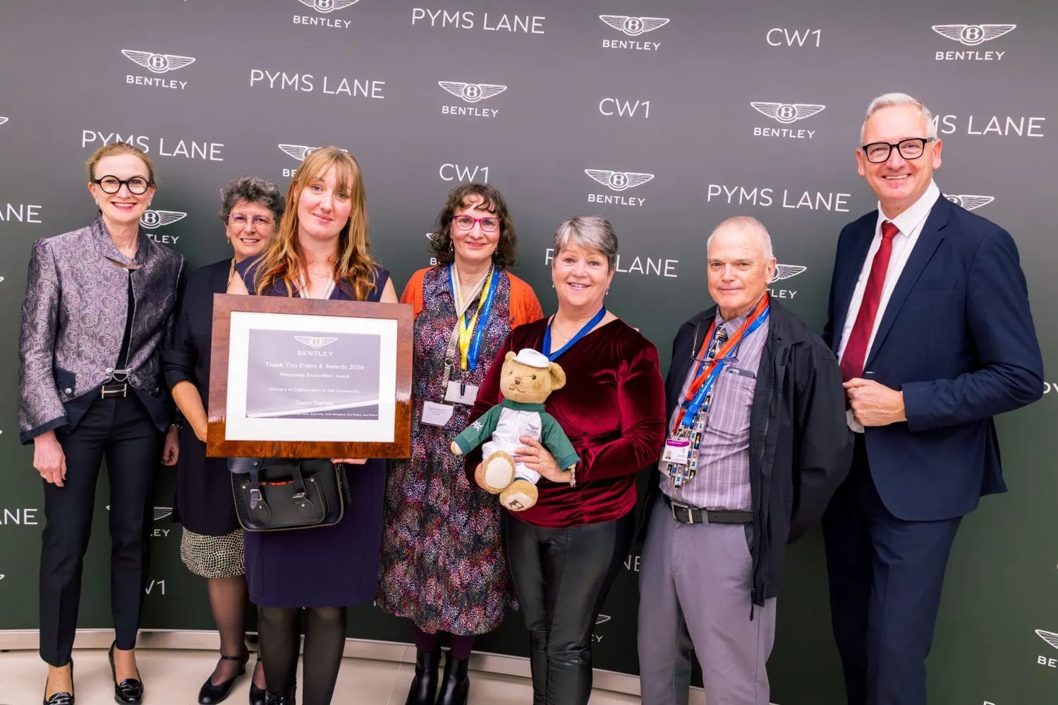 Bentley volunteer group with award and teddy bear - Saffarazzi Bentley volunteer group with award and teddy bear