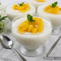 Coconut, Sago and Mango Dessert for Summer - Saffarazzi Glass cups of creamy coconut sago pudding topped with chopped mango on a summer table setting.