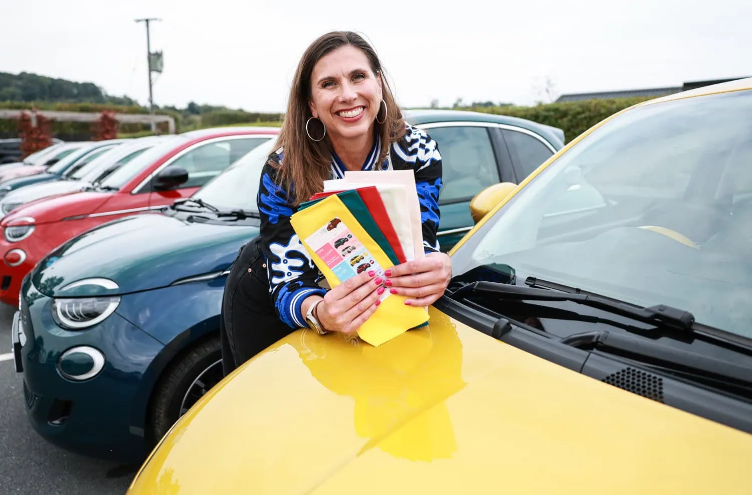 Swatches on Fiat 500 bonnet - Saffarazzi Colour consultant leaning on yellow Fiat 500 Hybrid bonnet.
