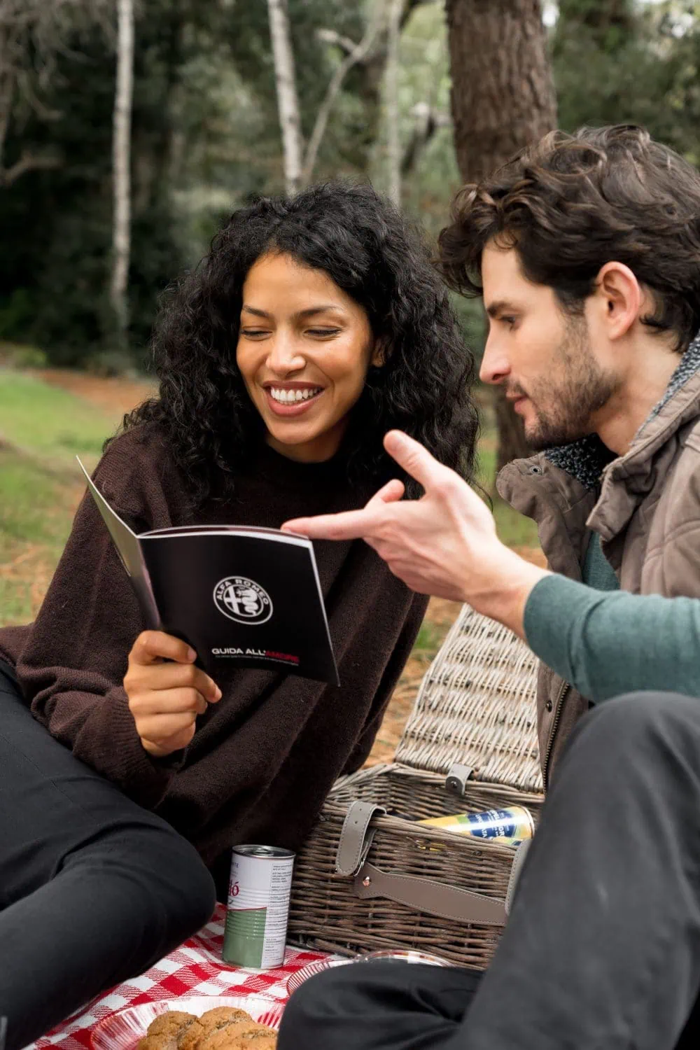 Couple reading Alfa Romeo guide at a picnic - Saffarazzi Couple reading Alfa Romeo guide at a picnic