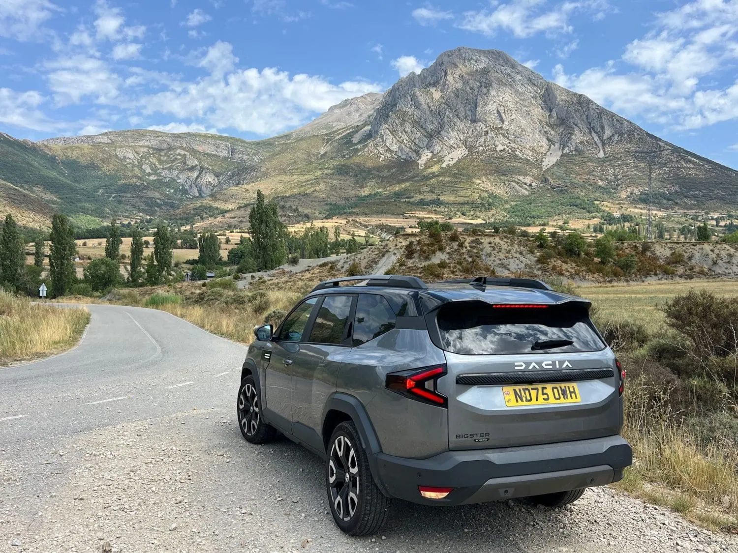 Dacia Bigster rear three-quarter view below a mountain peak - Saffarazzi Dacia Bigster rear three-quarter view below a mountain peak