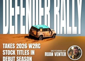 Land Rover Defender rally car climbing a desert sand dune
