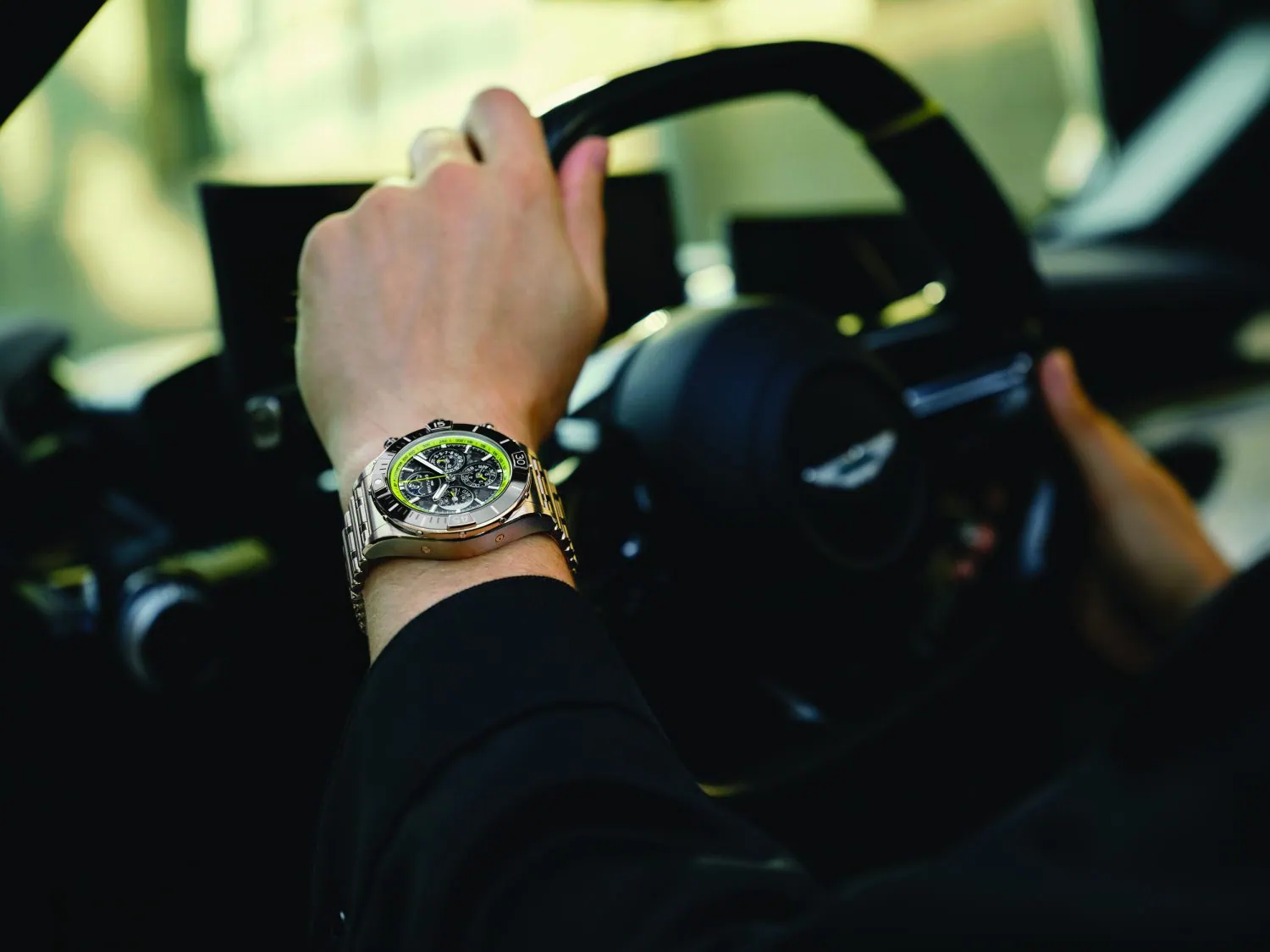 Driver wearing Breitling watch at Aston Martin Valhalla wheel - Saffarazzi Driver wearing Breitling watch at Aston Martin Valhalla wheel