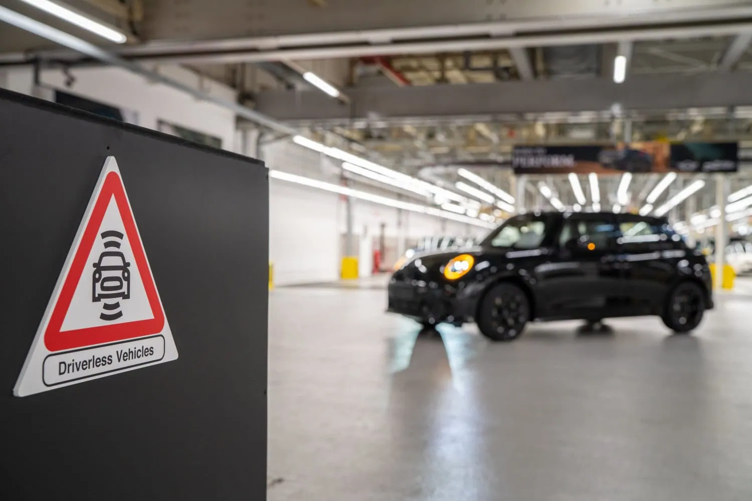 Driverless vehicles warning sign - Saffarazzi Driverless vehicles sign with black MINI Cooper in plant.
