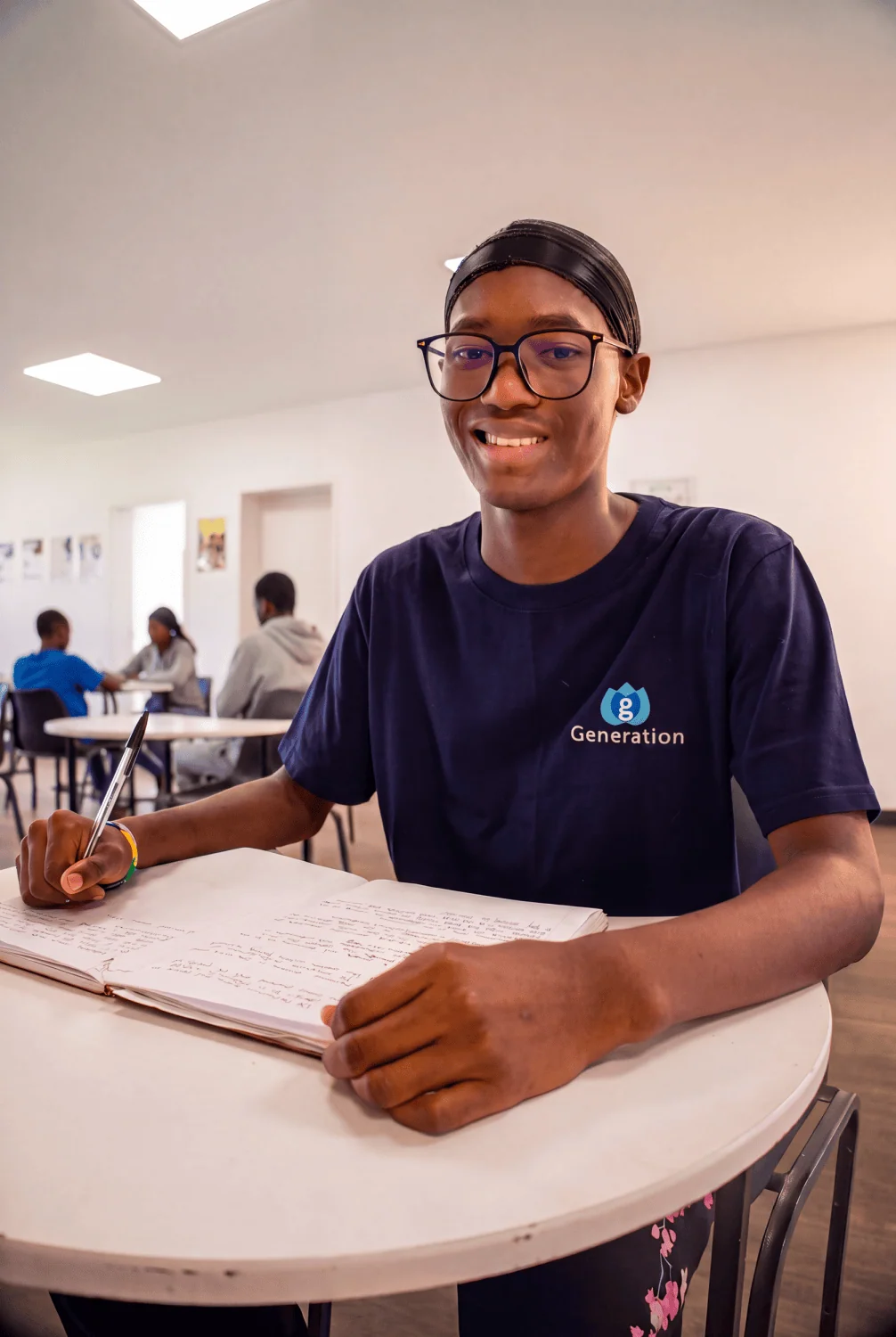 Student studying at table - Saffarazzi GAC bursary student writing notes in classroom.