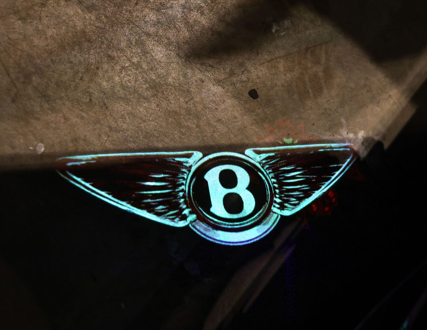 Illuminated Bentley winged logo projected on the floor