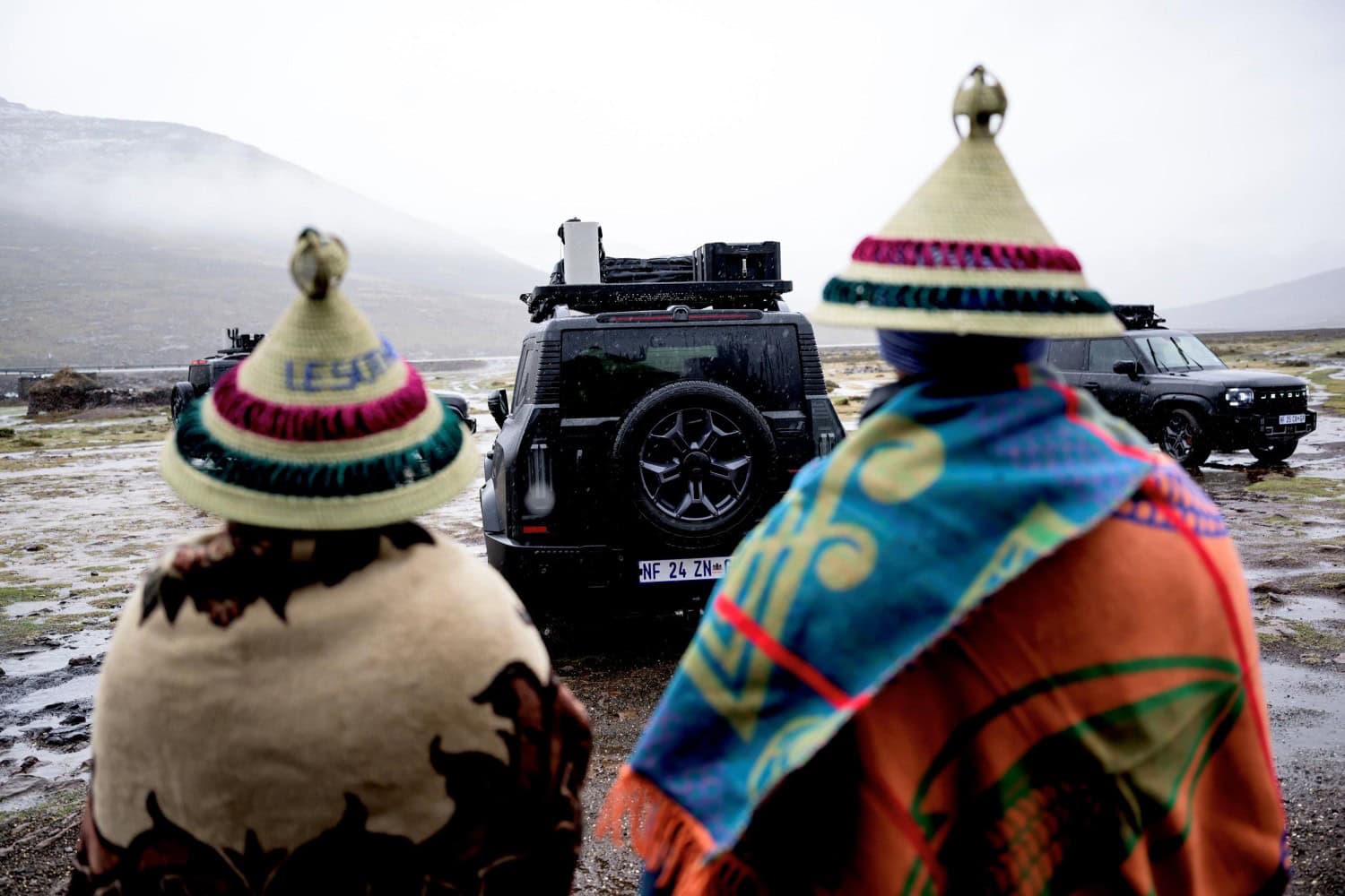 Jetour T2 convoy watched by men in Basotho hats.