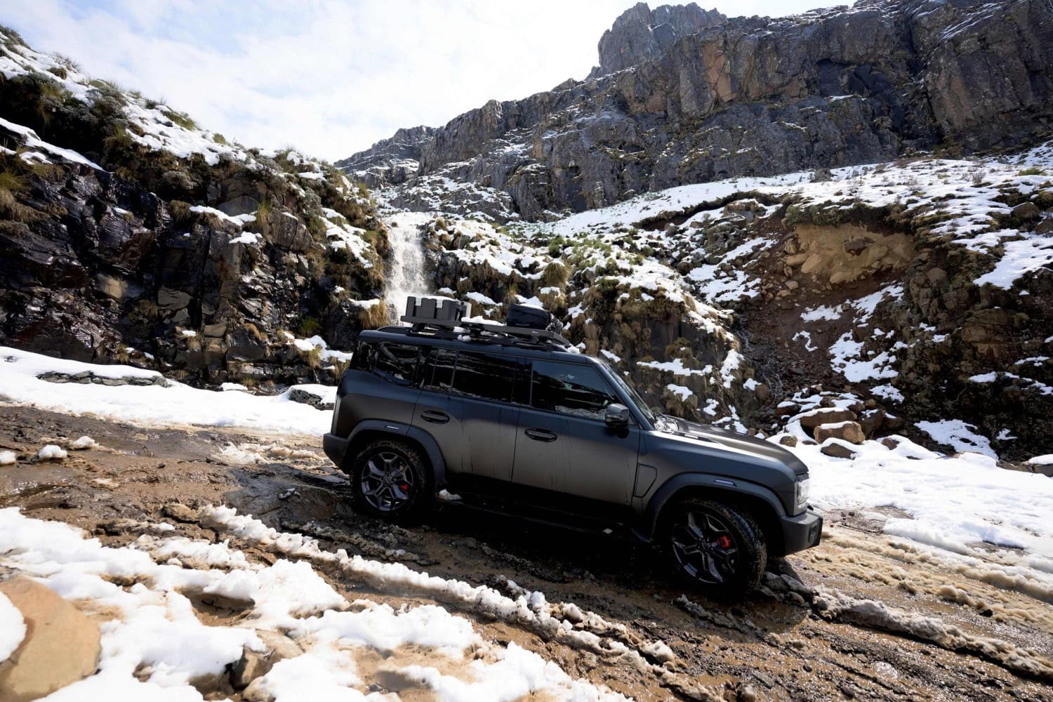 Jetour T2 side view on snowy mountain track.