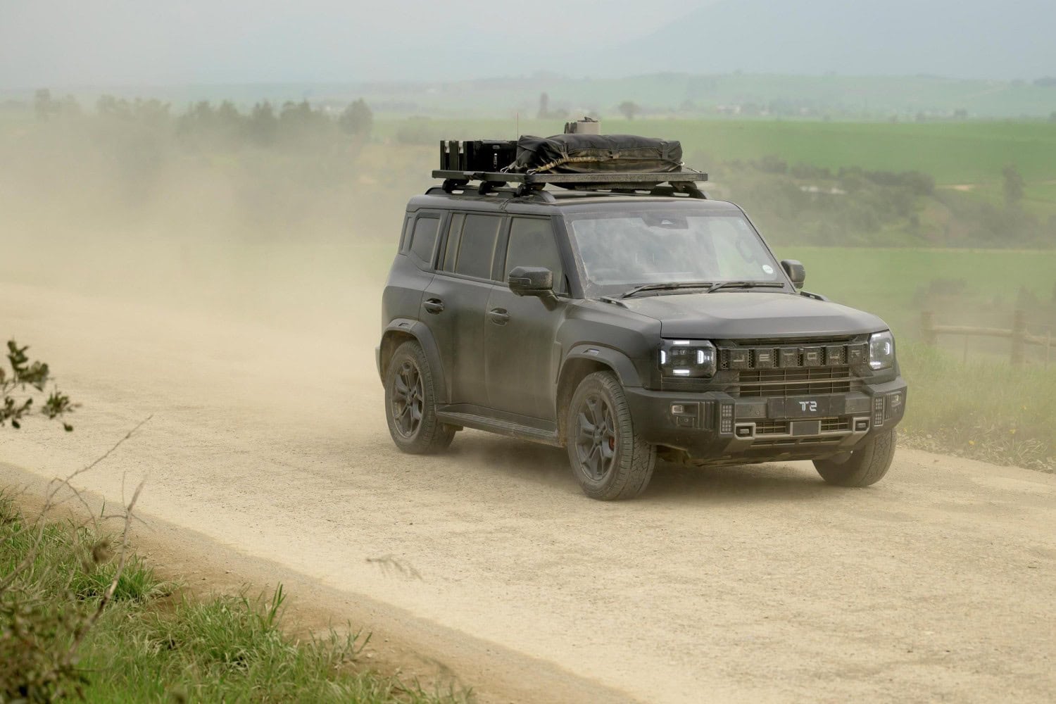 Jetour T2 SUV driving on a dusty gravel road.