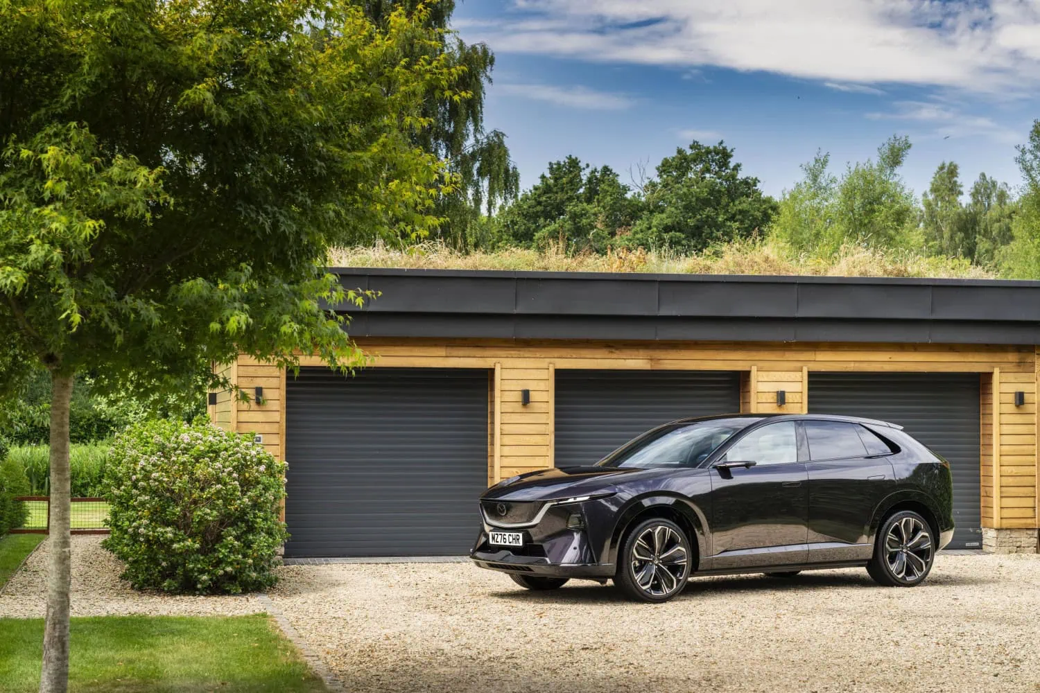 Mazda CX-6e by garages - Saffarazzi Mazda CX-6e parked in front of garage doors.
