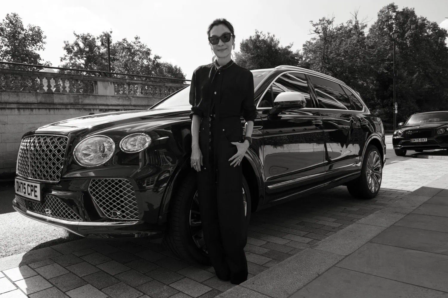 Michelle Yeoh standing beside a Bentley SUV - Saffarazzi Michelle Yeoh standing beside a Bentley SUV