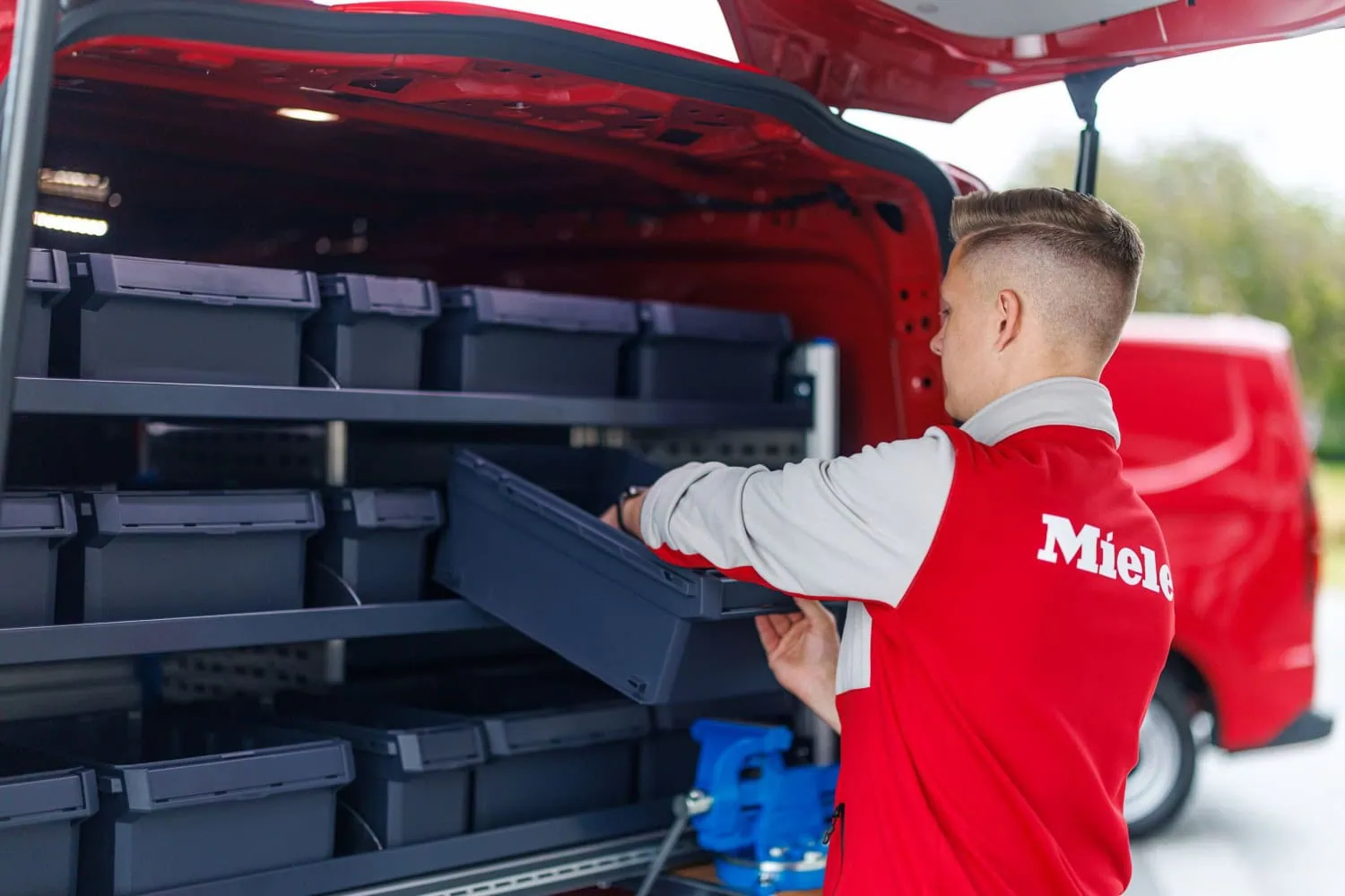Transporter cargo shelving system - Saffarazzi Miele technician loading storage boxes in Volkswagen Transporter.