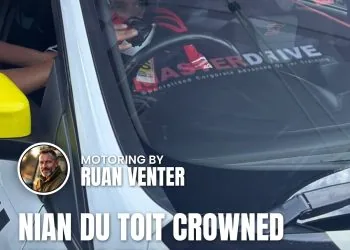Driver seated in MasterDrive branded race car in pit garage