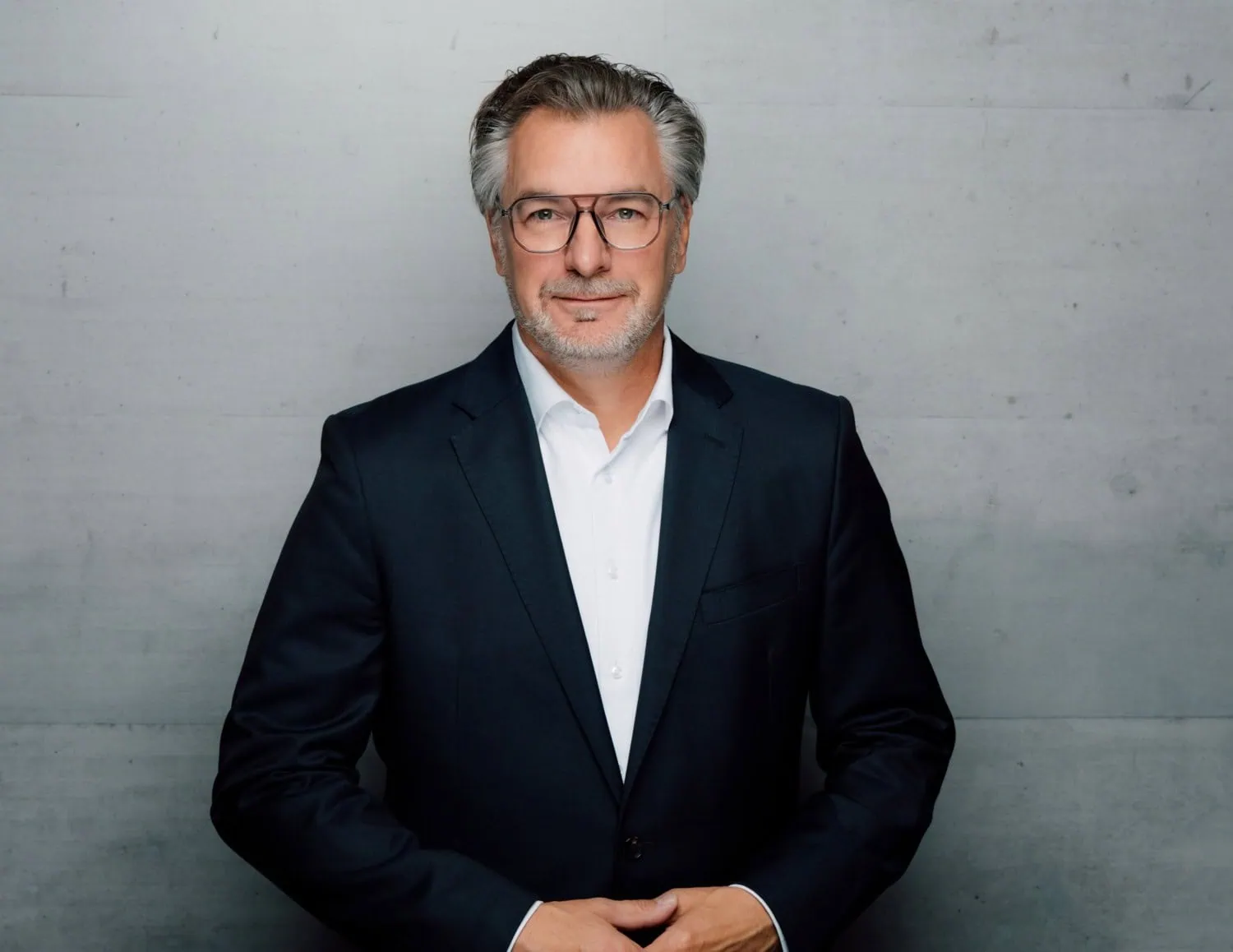 Porsche executive wearing glasses - Saffarazzi Porsche executive portrait in glasses and dark suit.