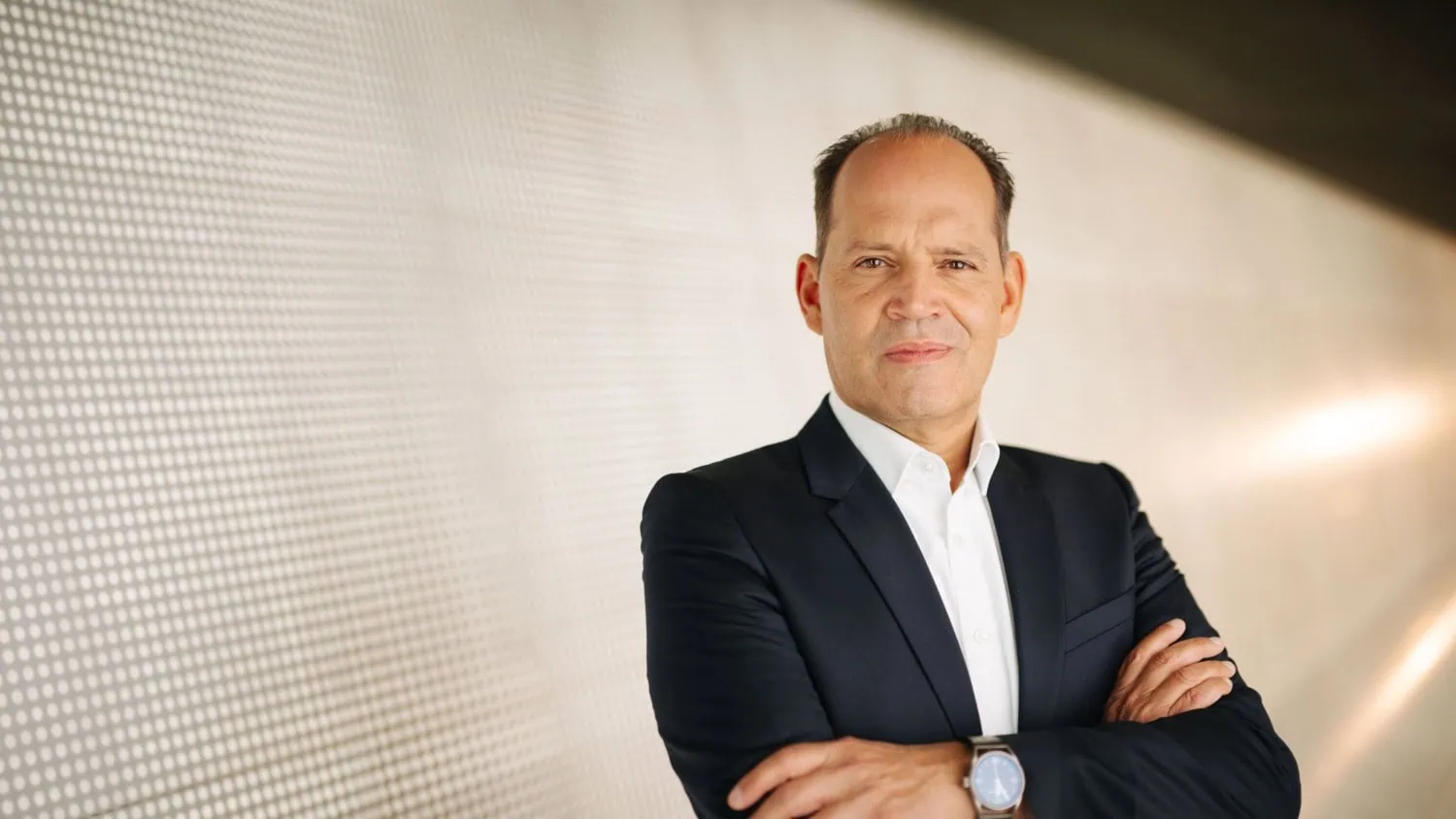 Executive wearing wristwatch portrait - Saffarazzi Porsche Technologies executive with watch and folded arms.
