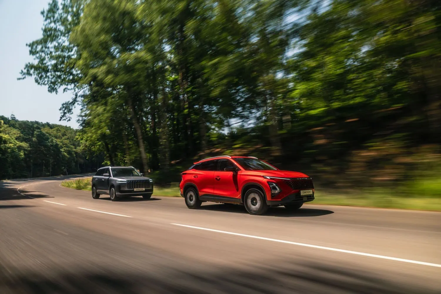 Red OMODA and JAECOO SUV - Saffarazzi Red OMODA SUV and JAECOO SUV driving on road.