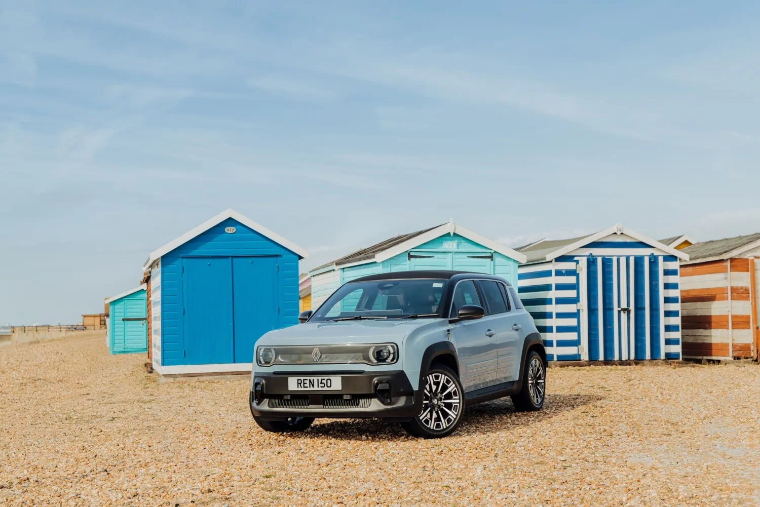 Renault 4 by beach huts - Saffarazzi Renault 4 E-Tech electric front three-quarter view by beach huts.