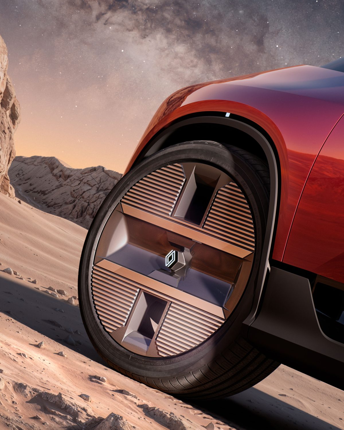Renault E-Space Concept front wheel close-up - Saffarazzi Close-up of a red car wheel and tire on a sandy desert slope with rocky hills and a starry night sky in the background.