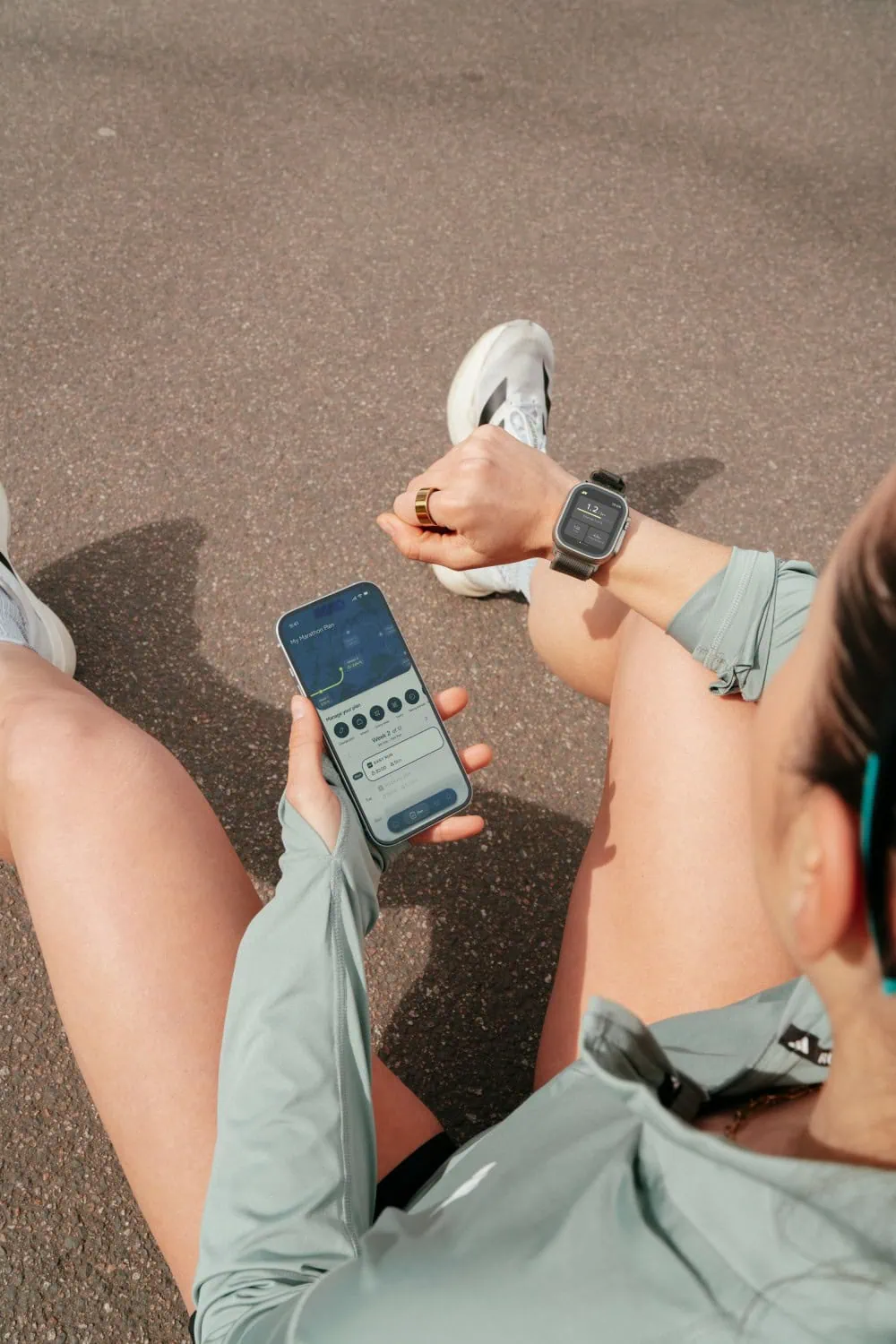Runner using training app - Saffarazzi Runner checking the URUNN app on a smartphone.