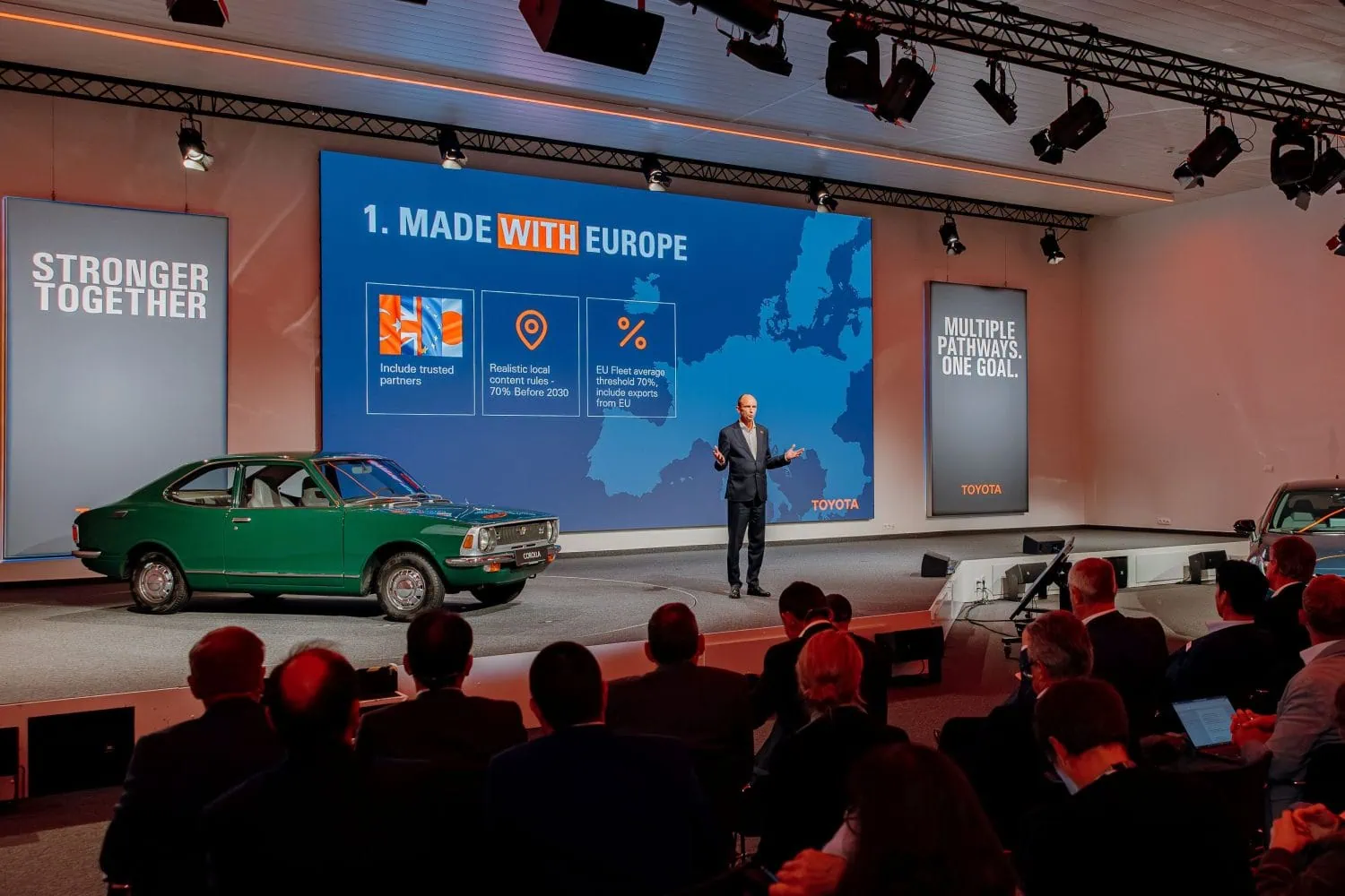 Toyota executive presenting Made with Europe strategy on stage - Saffarazzi Toyota executive presenting Made with Europe strategy on stage