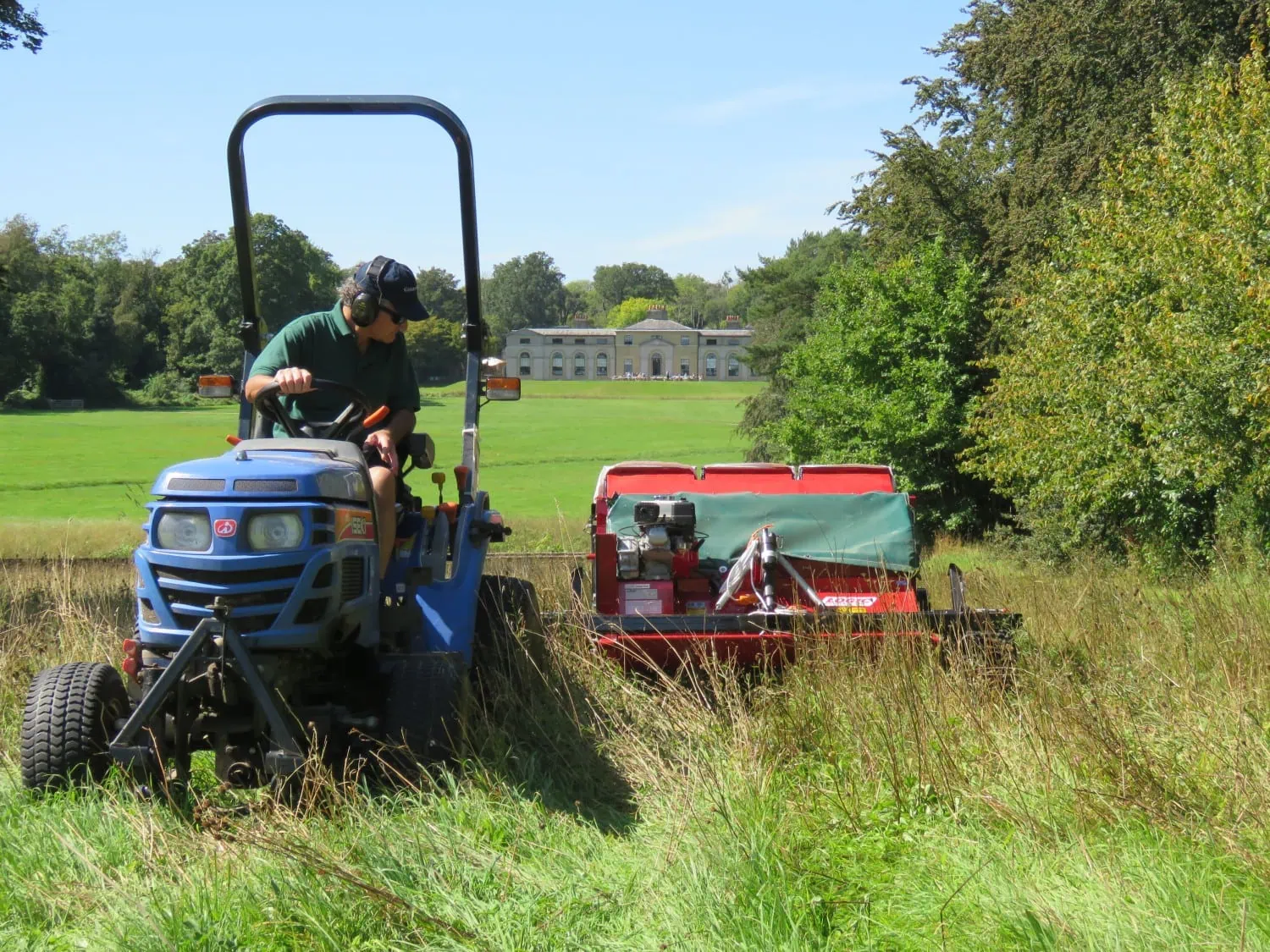 Tractor mowing estate meadow - Saffarazzi Tractor mowing meadow grass on the Goodwood Estate.