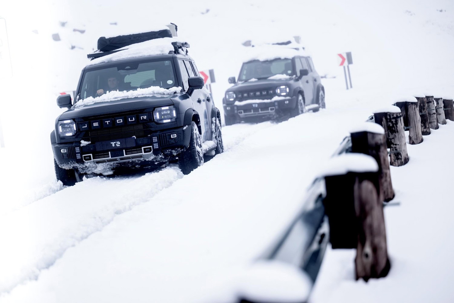 Two Jetour T2 SUVs driving on a snowy road.