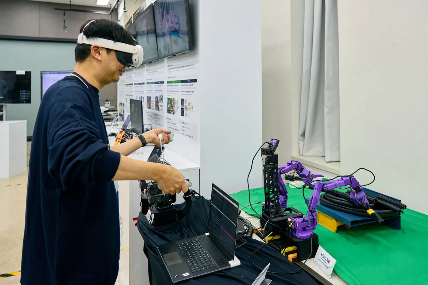 VR robot arm teleoperation - Saffarazzi VR headset operator controlling purple robot arms.