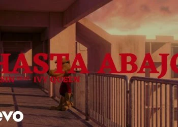 Music video cover still with bold red text 'HASTA ABAJO' across a sunlit walkway; smaller text 'WISIN feat. IVY QUEEN' and a white Vevo logo in the corner.